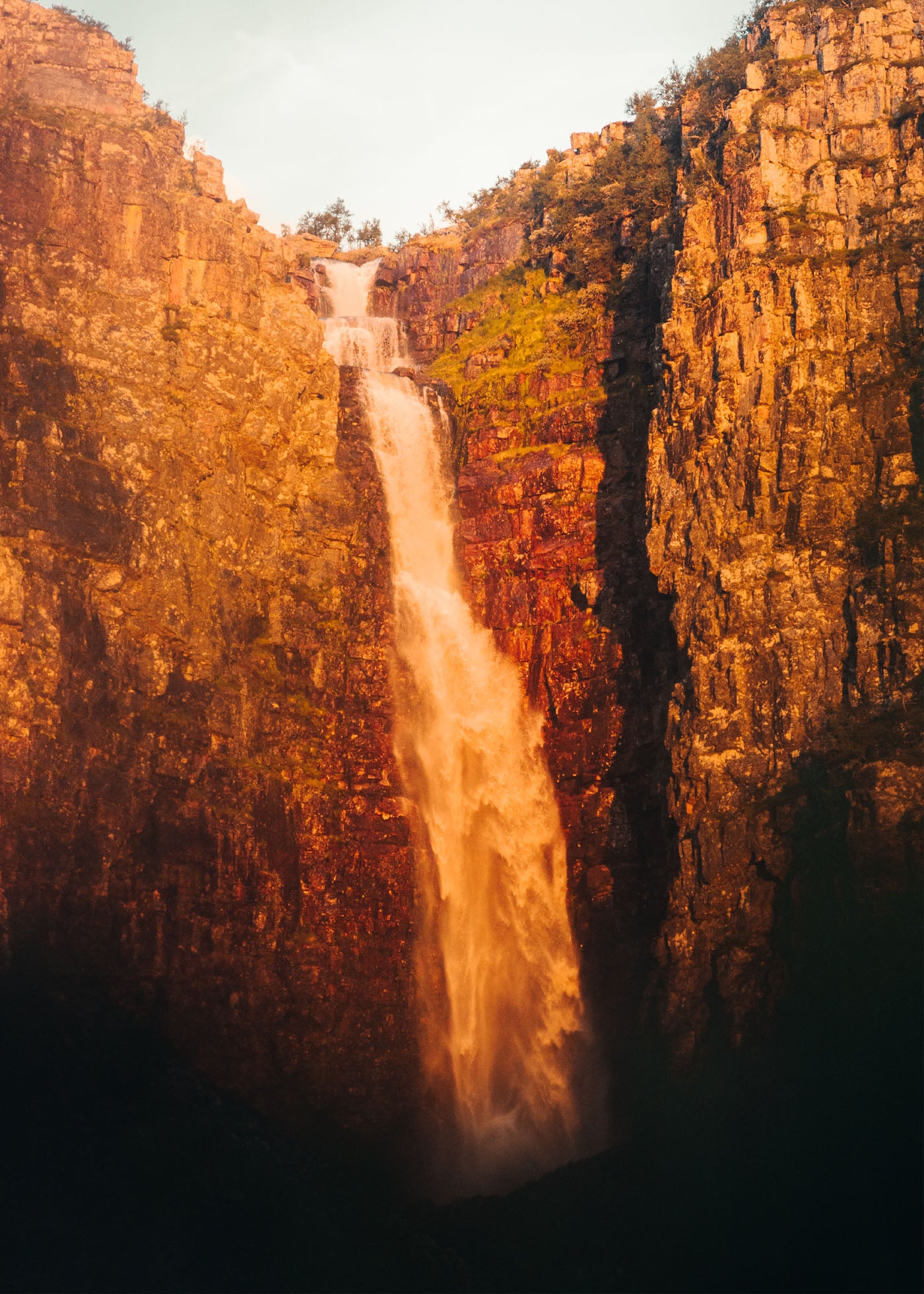 Njupeskärs vattenfalls midsommarljus mellan bergsväggar. Poster i olika storlekar: 30x40 cm, 40x50 cm, 50x70-cm, 70x100 cm.