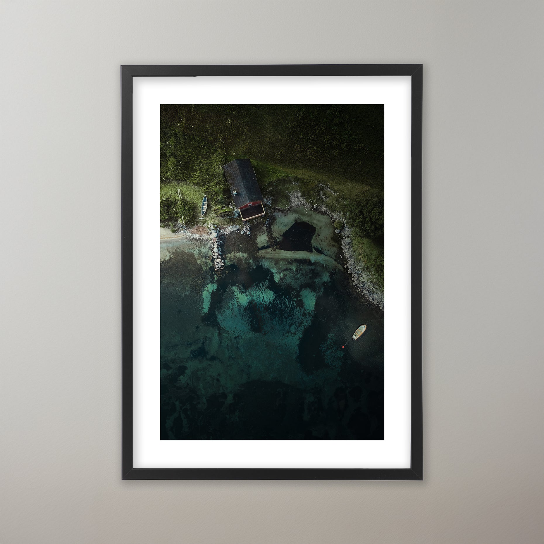 Drönarbild över ett båthus vid en kristallklar smaragdgrön fjord i Norge omgiven av grönskande skog. Poster i olika storlekar: 30x40 cm, 40x50 cm, 50x70-cm, 70x100 cm.