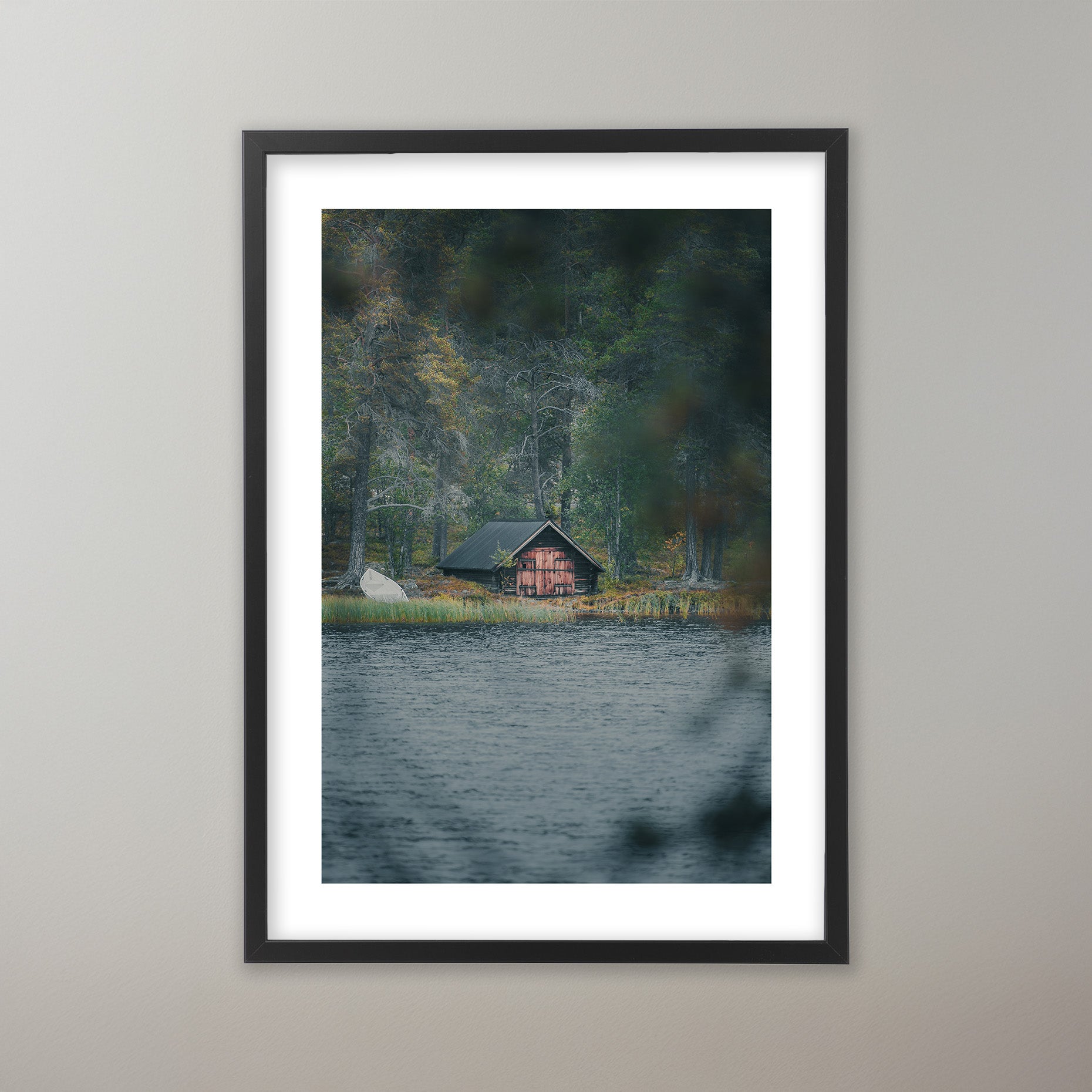 Ett rött trähus med mörkt tak vid en sjökant, omgivet av höstskog med gula och gröna träd. Poster i olika storlekar: 30x40 cm, 40x50 cm, 50x70-cm, 70x100 cm.
