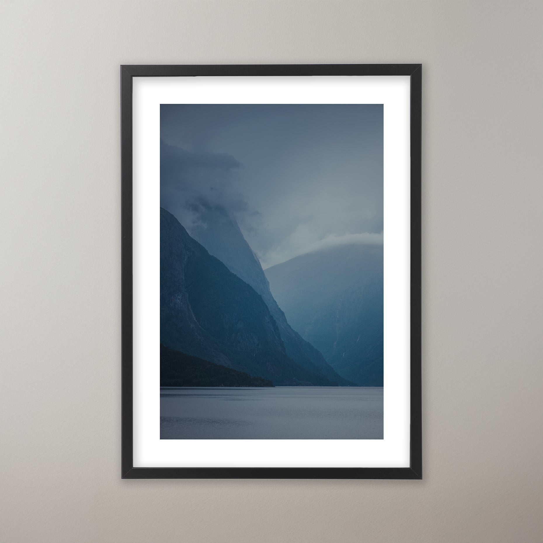 Dimmig fjordlandskap med höga blå berg som reser sig från lugnt vatten. Poster i olika storlekar: 30x40 cm, 40x50 cm, 50x70-cm, 70x100 cm.