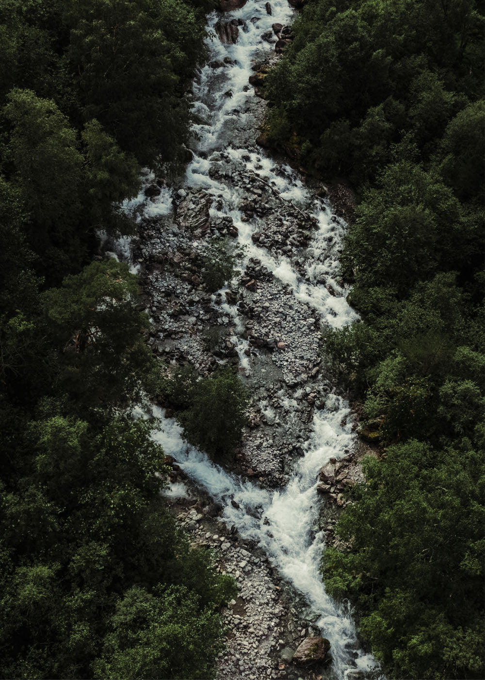 Drönarfoto av en fors genom en grönskade skog i Norge. Poster i olika storlekar: 30x40 cm, 40x50 cm, 50x70-cm, 70x100 cm.