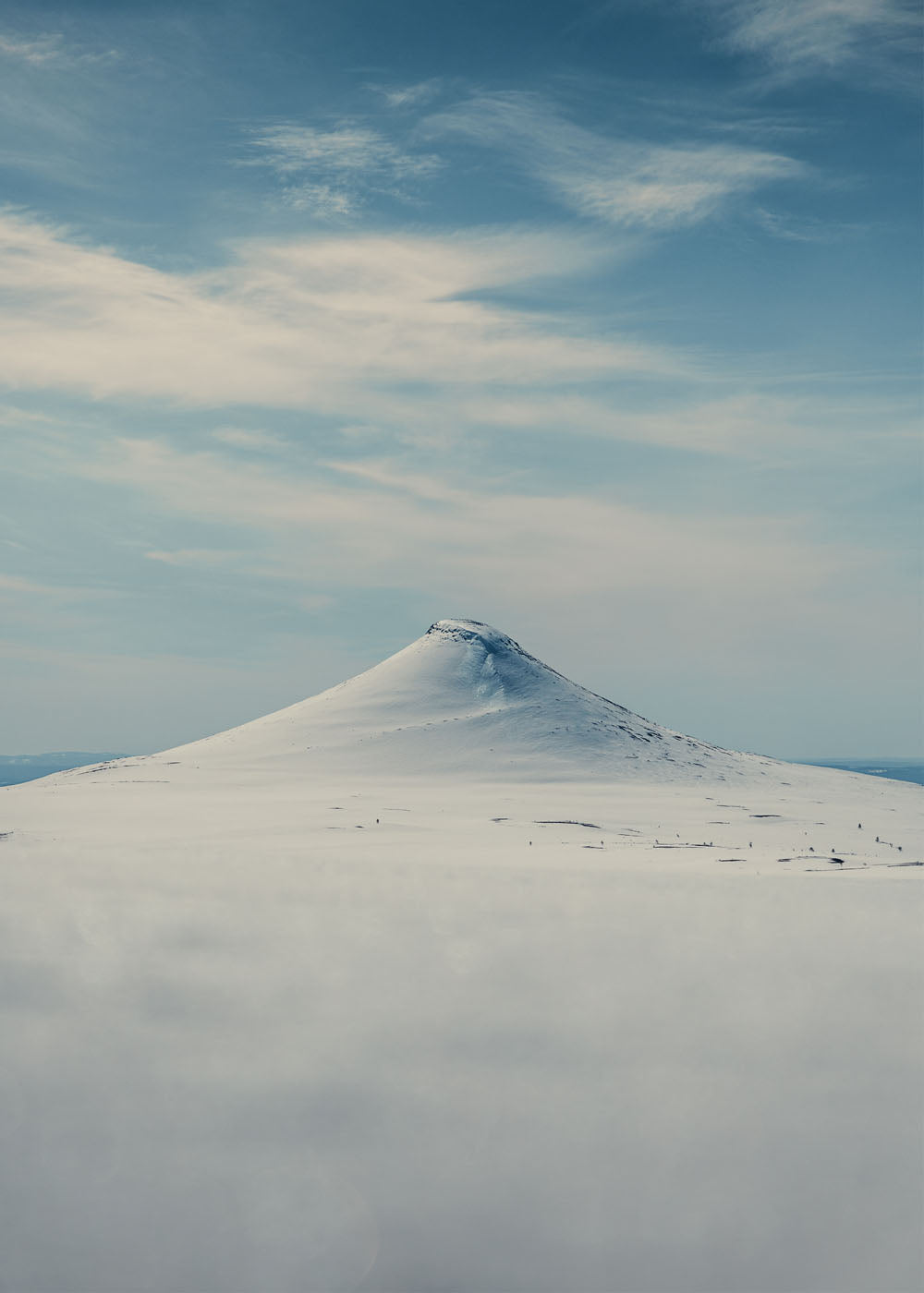 Städjan täckt i snö framför en ljusblå himmel. Poster i olika storlekar: 30x40 cm, 40x50 cm, 50x70-cm, 70x100 cm.