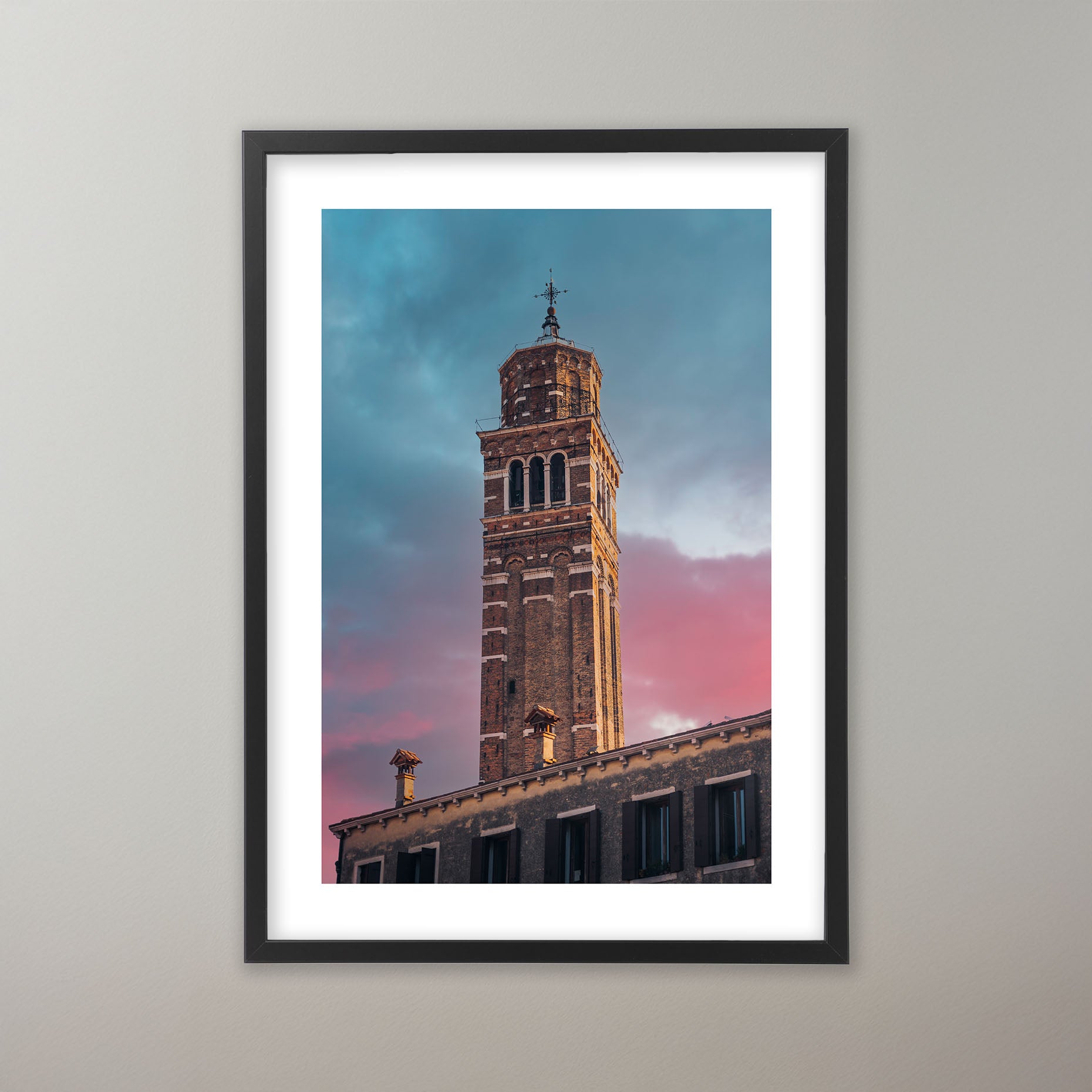 Venetianskt klocktorn i rödbrunt tegel mot en dramatisk himmel i skymningen med färgskiftningar från blått till rosa. Poster i olika storlekar: 30x40 cm, 40x50 cm, 50x70-cm, 70x100 cm.