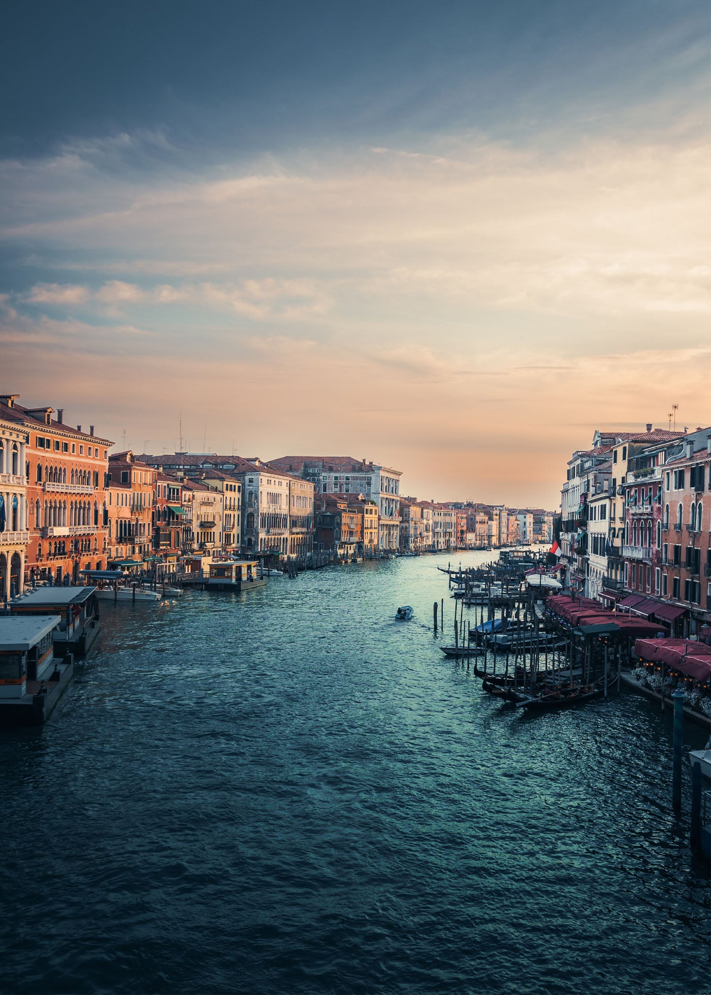Canal Grande i Venedig vid solnedgång med historiska palats längs vattnet och gondoler som färdas på kanalen. Himlen lyser i varma orange och rosa toner. Poster i olika storlekar: 30x40 cm, 40x50 cm, 50x70-cm, 70x100 cm.